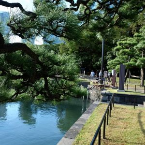 View along the waterside path at the Hamarikyu gardens, with Tokyo's skyscrapers in the background 