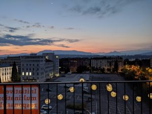 Un coucher de soleil à Genève, avec l'affiche de "L'Initiaive pour des multinationales responsables" en vue.