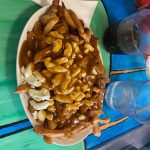Une assiette de Poutine- composée de la sauce, du fromage et des frites