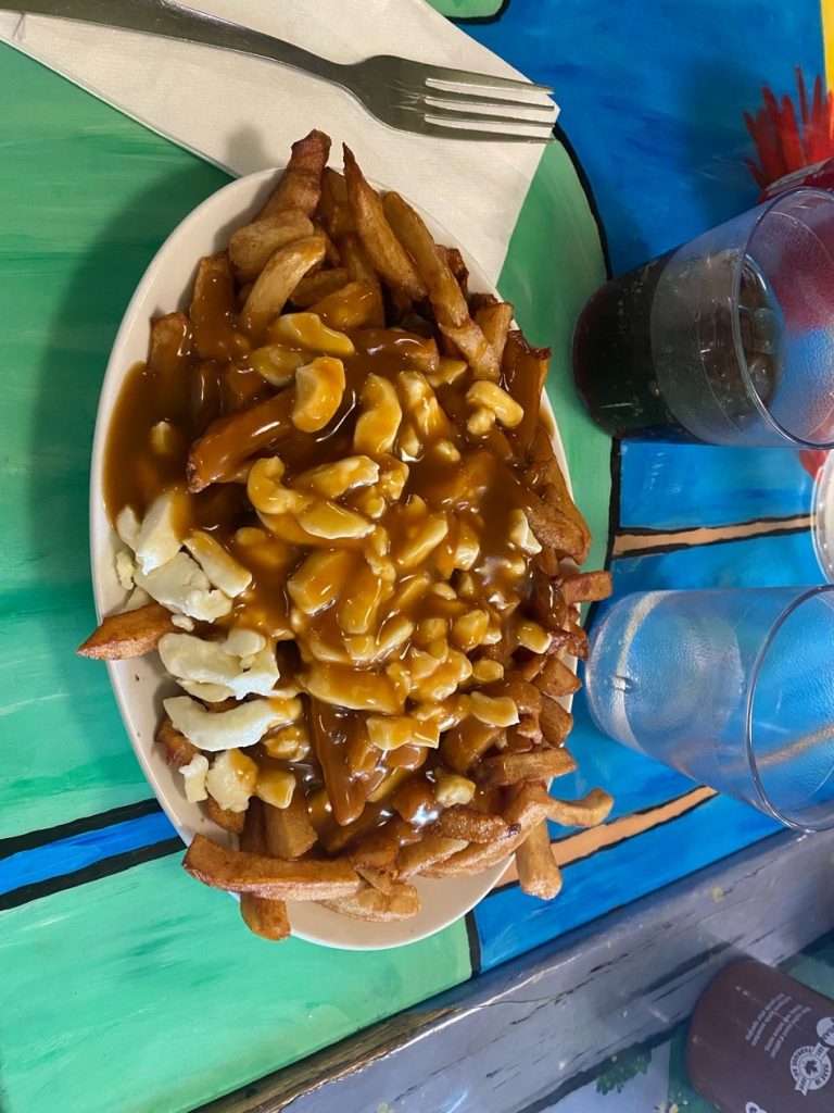 Une assiette de Poutine- composée de la sauce, du fromage et des frites